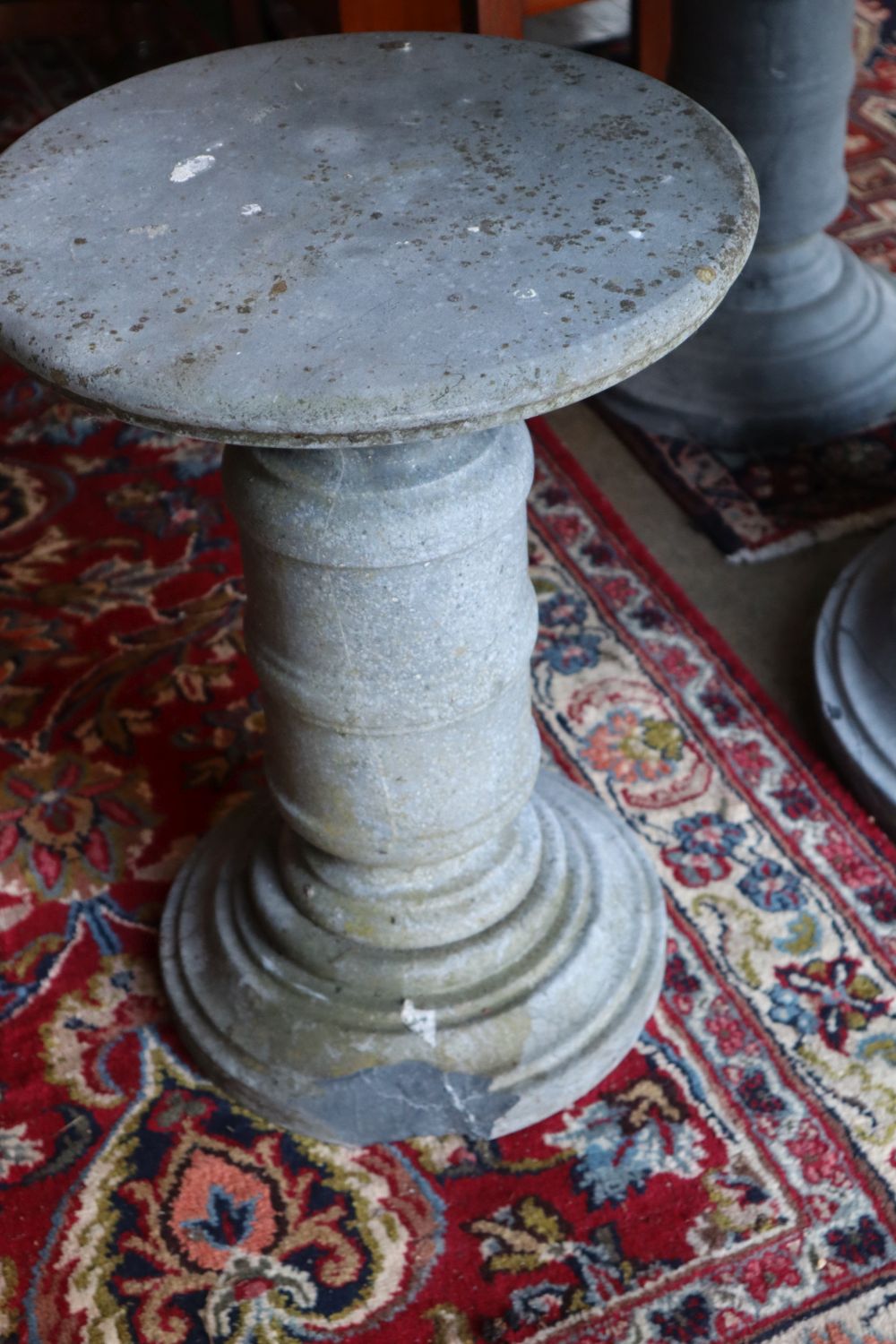 A circular reconstituted stone garden table, 100cm diameter, 80cm high and four matching stools,